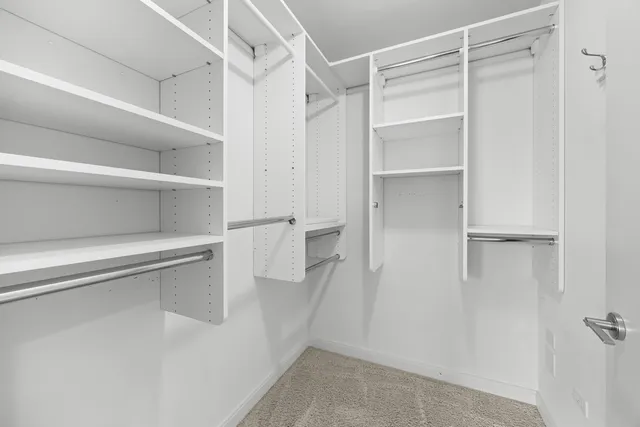 a view of walk in closet with empty racks