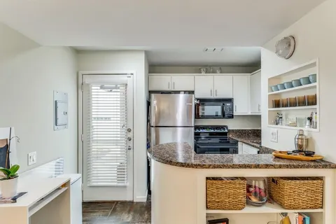 a kitchen with stainless steel appliances granite countertop a refrigerator and a stove top oven