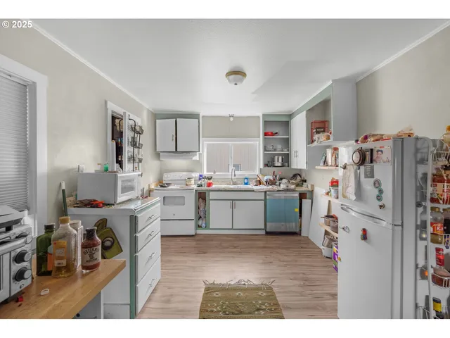 a kitchen with stainless steel appliances a stove a sink a refrigerator and cabinets