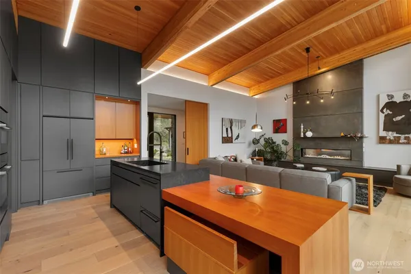 a kitchen with stainless steel appliances kitchen island granite countertop a table chairs in it and wooden floors