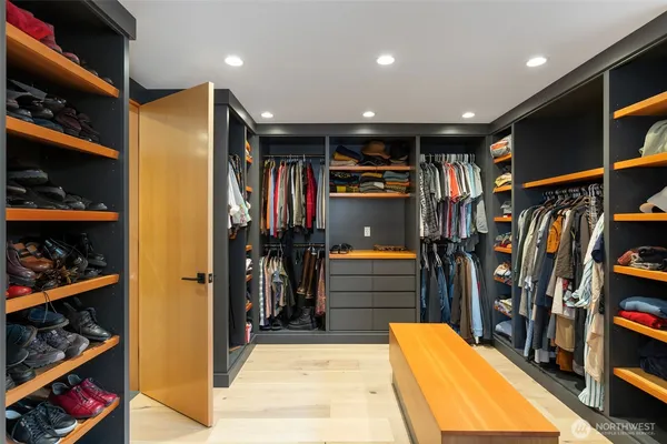 a view of walk in closet with clothes and shoes
