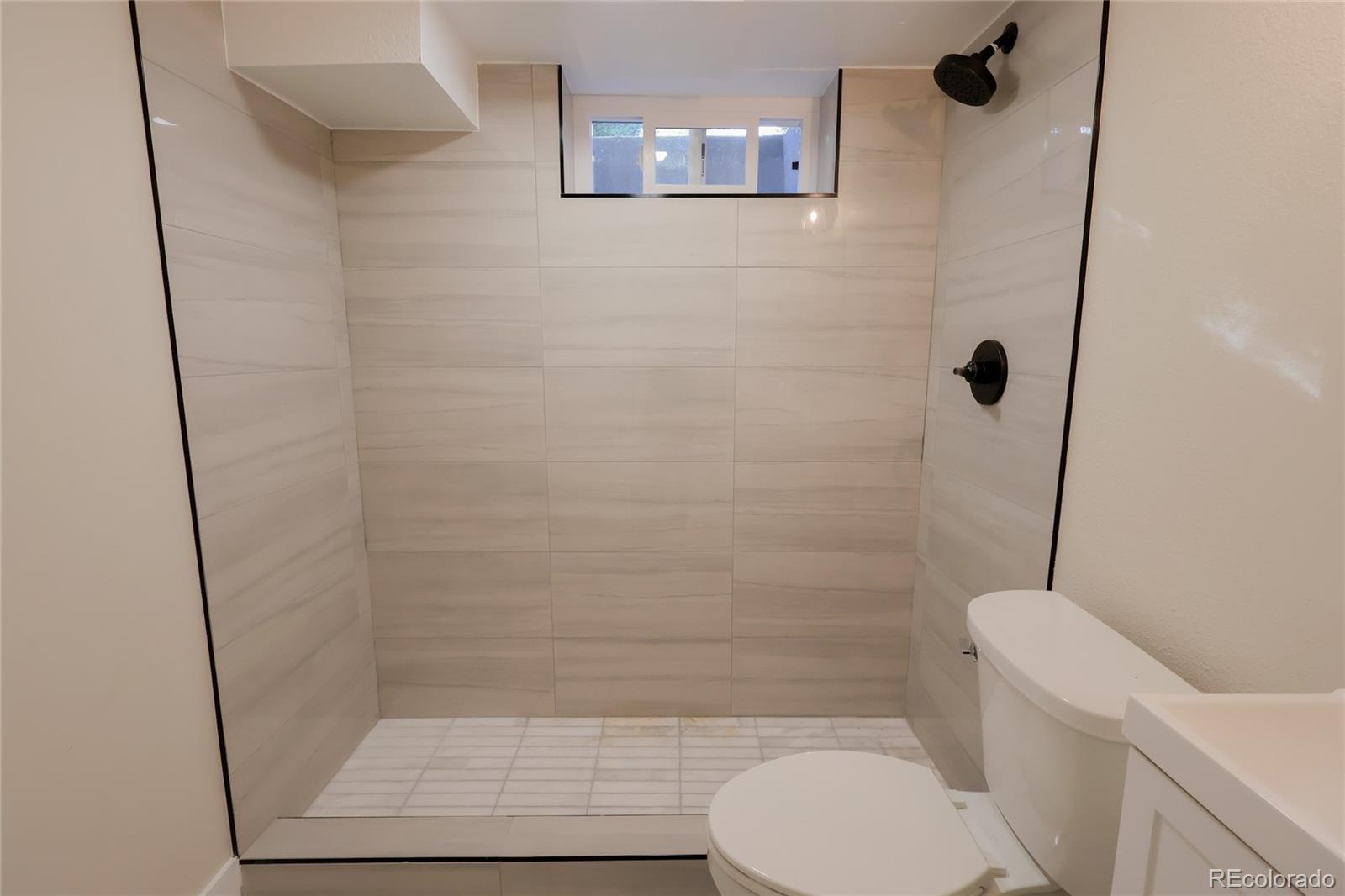 1045 Locust Street Denver, CO 80220 - Photo 15 of 18 a bathroom with a shower and a toilet