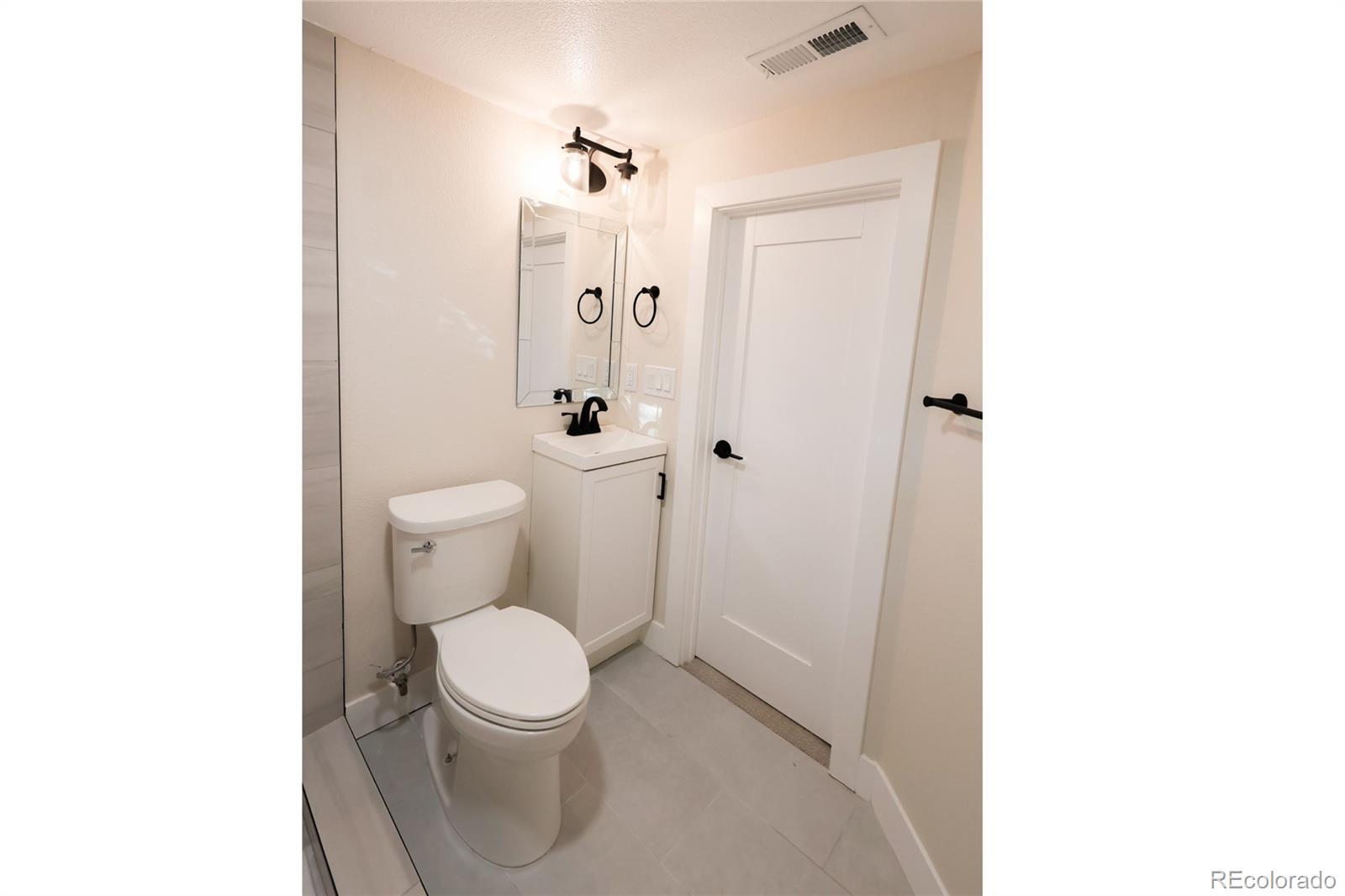 1045 Locust Street Denver, CO 80220 - Photo 16 of 18 a white toilet sitting next to a bathroom sink