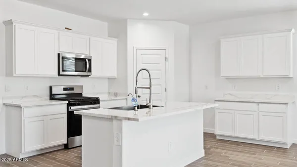 a kitchen with stainless steel appliances granite countertop a sink stove microwave and cabinets