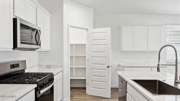 a kitchen with white cabinets and appliances