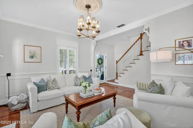 a living room with furniture and a chandelier
