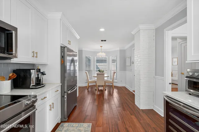 a kitchen with stainless steel appliances a stove a sink a refrigerator and wooden floor