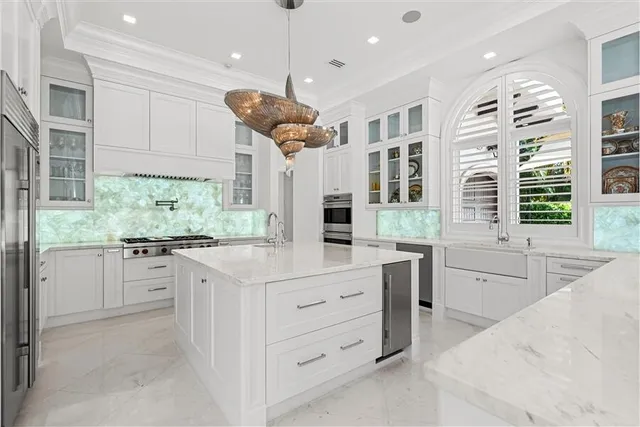 a kitchen with stainless steel appliances kitchen island granite countertop a stove a sink and a refrigerator