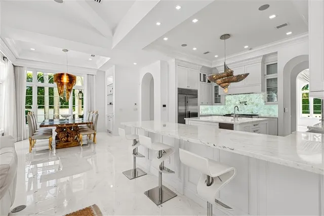 a large white kitchen with lots of counter space and windows