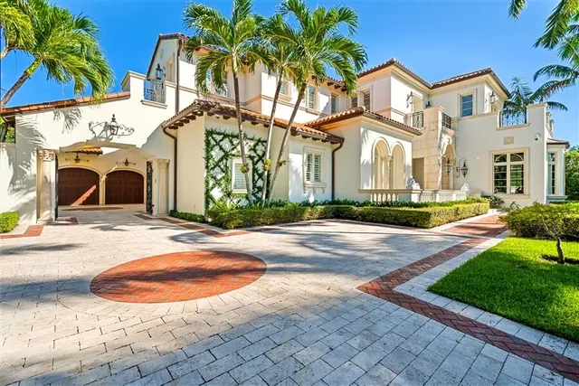 a view of a white house with a small yard and plants