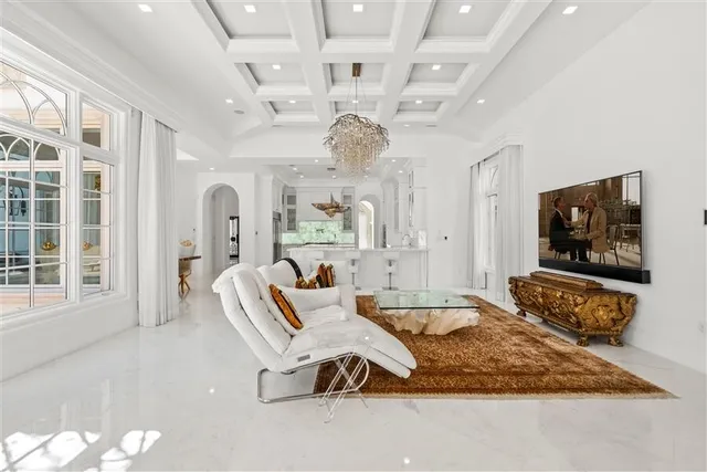 a living room with furniture chandelier and a large window