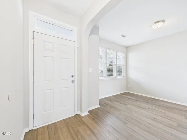 a view of a room with wooden floor and white walls