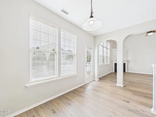 a view of empty room with wooden floor and fireplace