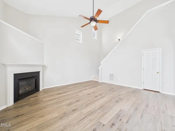 an empty room with windows and fan