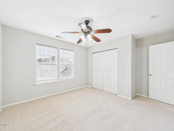 an empty room with a window and a fan