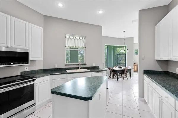 a kitchen with granite countertop a sink and white cabinets
