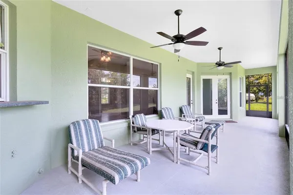 a view of a pool with a table and chairs under an umbrella