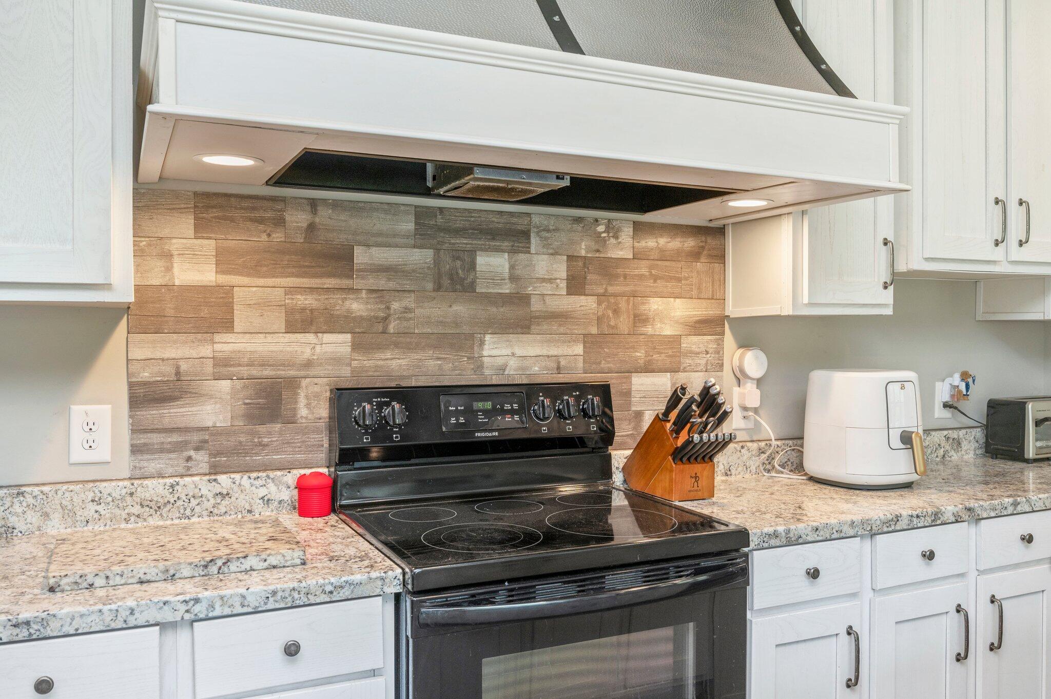 5979 Old River Road Baker, FL 32531 - Photo 12 of 46 a kitchen with granite countertop a stove and cabinets