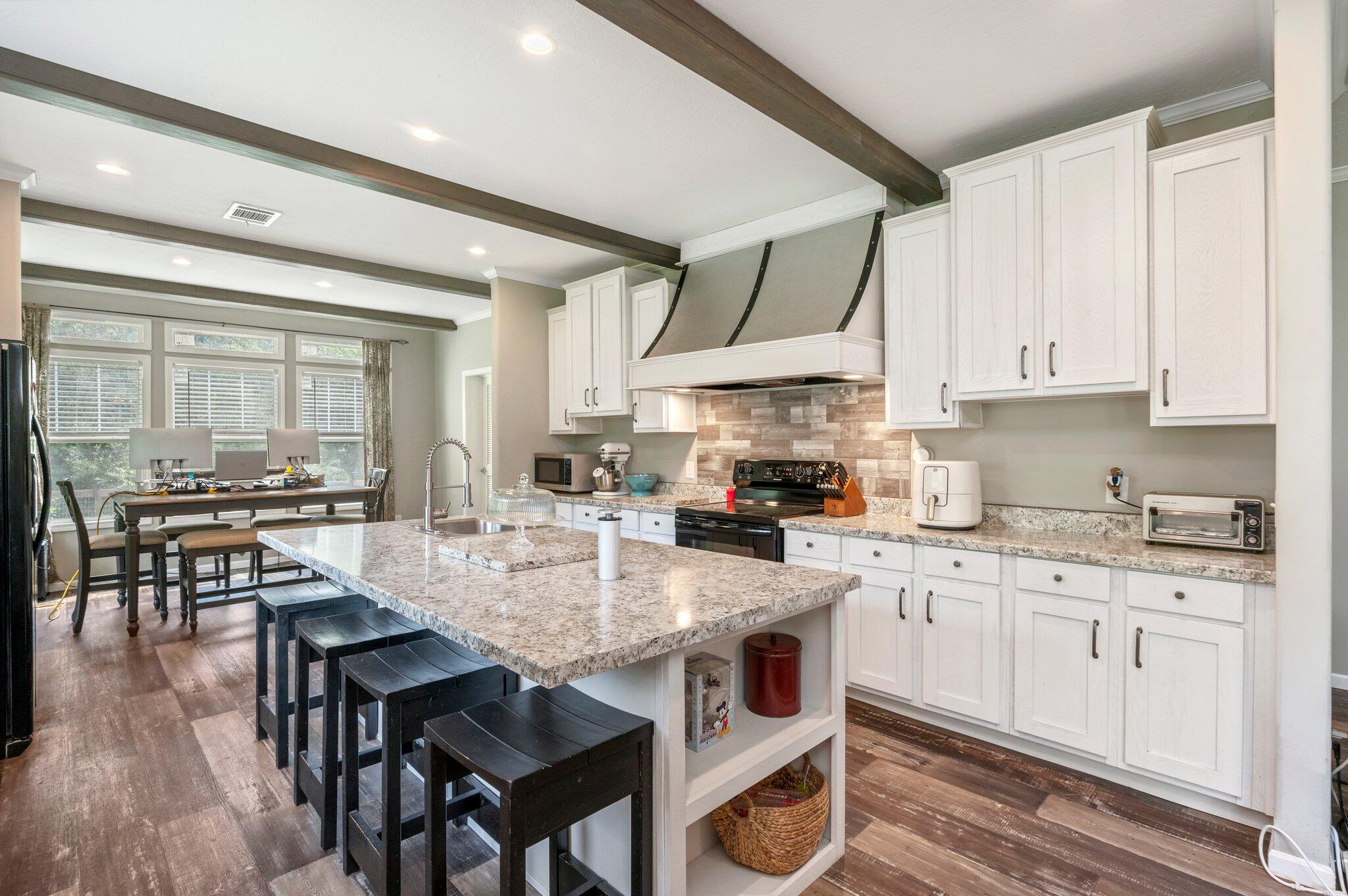 5979 Old River Road Baker, FL 32531 - Photo 13 of 46 a kitchen with granite countertop a stove a sink a dining table and chairs