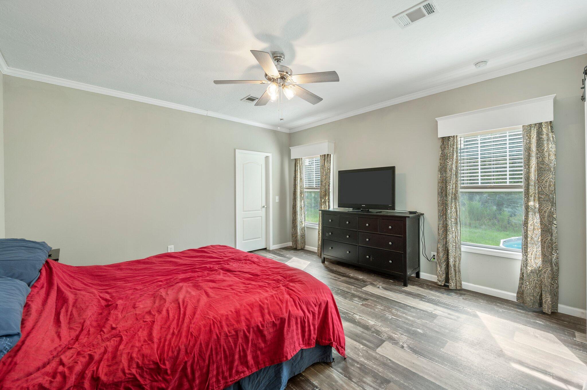 5979 Old River Road Baker, FL 32531 - Photo 18 of 46 a spacious bedroom with a bed and a flat screen tv
