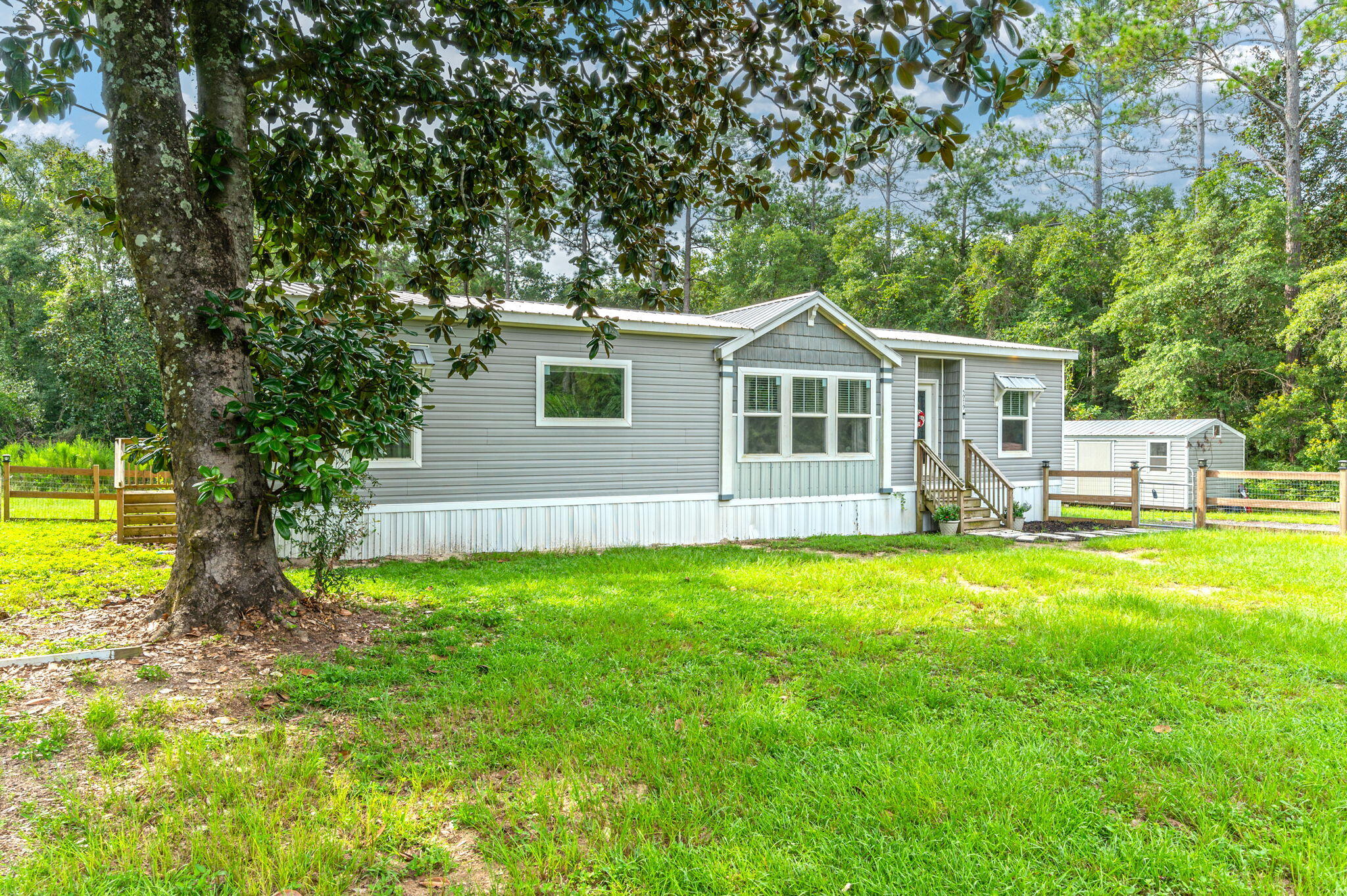 5979 Old River Road Baker, FL 32531 - Photo 2 of 46 a front view of a house with yard and green space