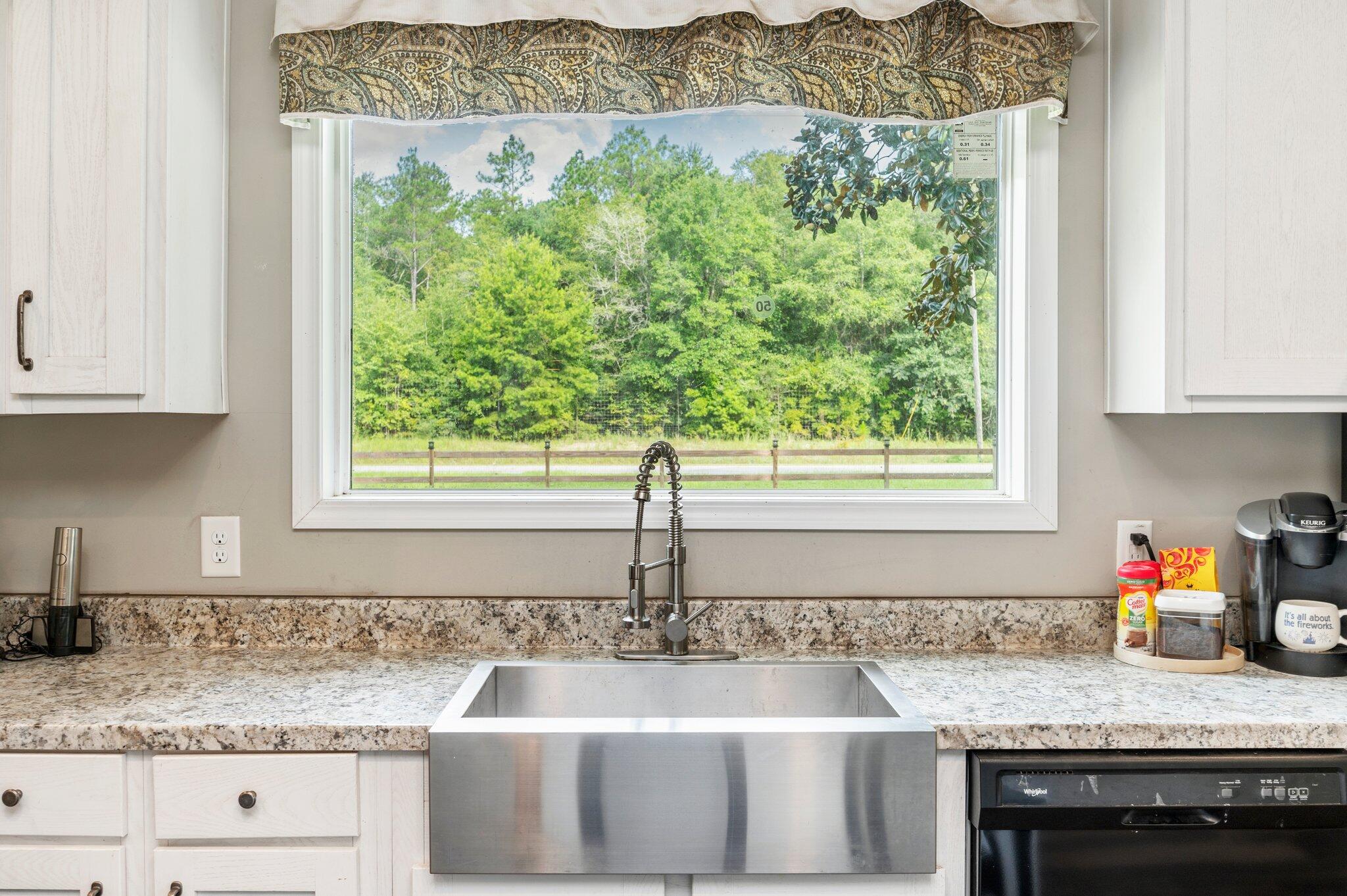 5979 Old River Road Baker, FL 32531 - Photo 10 of 46 a kitchen with granite countertop a sink window and cabinets