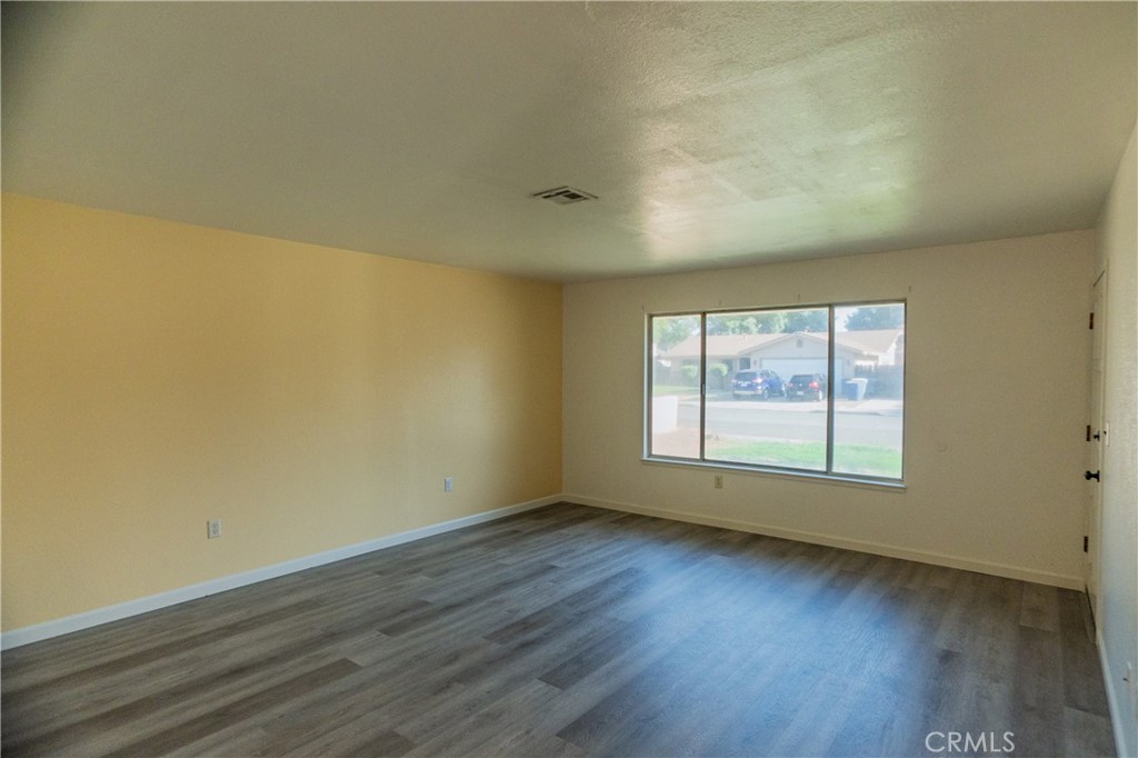 749 Junipero Court Merced, CA 95348 - Photo 15 of 57 an empty room with wooden floor and windows