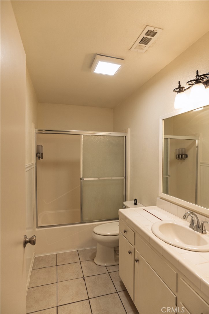 749 Junipero Court Merced, CA 95348 - Photo 17 of 57 a bathroom with a granite countertop sink a toilet and shower