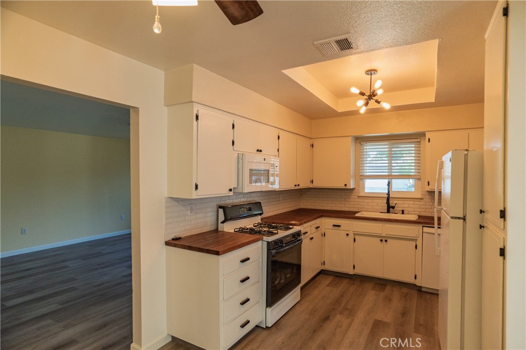 749 Junipero Court Merced, CA 95348 - Photo 9 of 57 a kitchen with stainless steel appliances granite countertop a sink cabinets and wooden floor