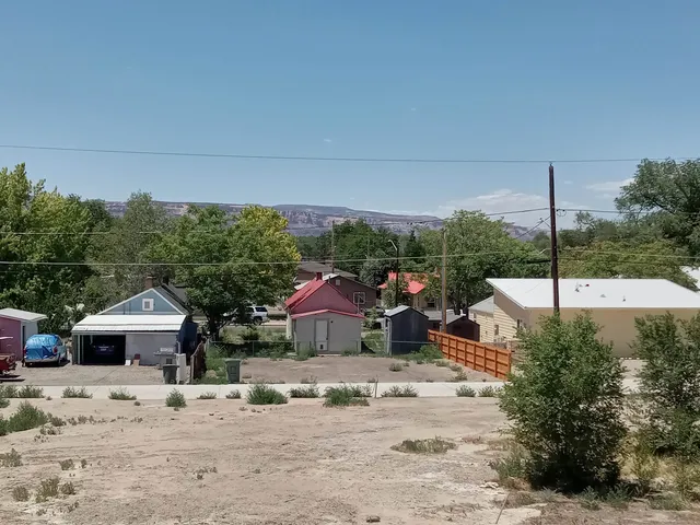 a view of a white house with a yard and sitting area
