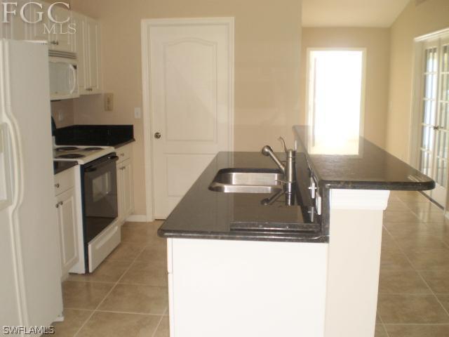 640 Homestead Road South Lehigh Acres, FL 33974 - Photo 8 of 21 a kitchen with a sink a stove and a refrigerator