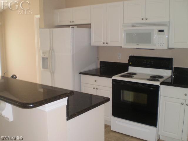 640 Homestead Road South Lehigh Acres, FL 33974 - Photo 9 of 21 a kitchen with granite countertop white cabinets and white stove