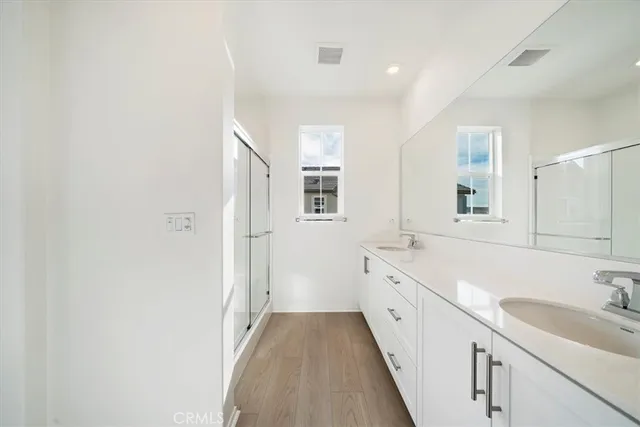 a spacious bathroom with a double vanity sink and mirror