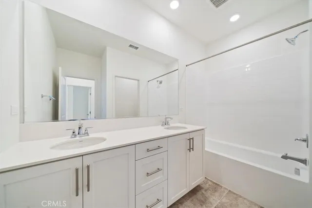 a bathroom with a sink double vanity granite tub and shower