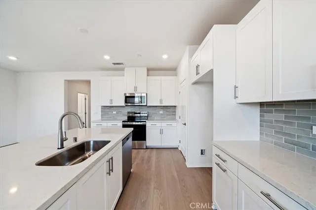 a kitchen with stainless steel appliances a sink a stove and a refrigerator