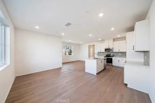 a view of kitchen with wooden floor and electronic appliances