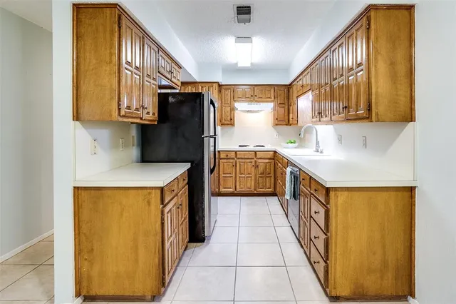 a kitchen with stainless steel appliances granite countertop a refrigerator a sink and a stove