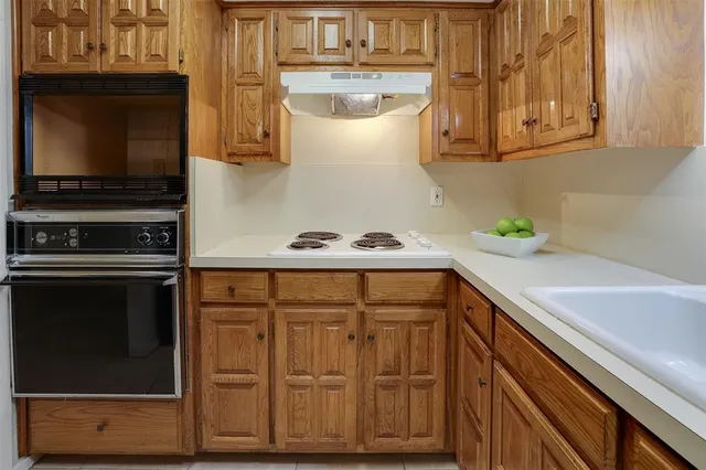 a kitchen with stainless steel appliances granite countertop a sink and a stove