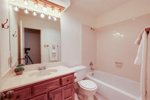 a bathroom with a sink a toilet and a large mirror