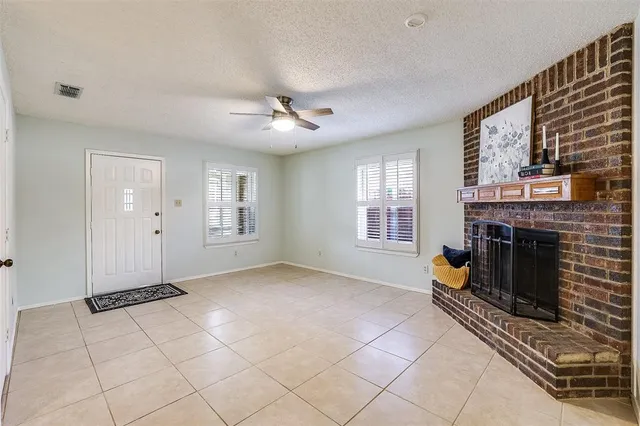 a view of an empty room with a fireplace and a window