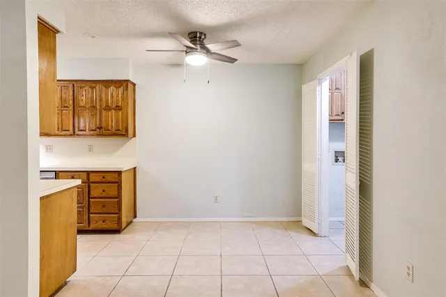 a view of an empty room with window and cabinet