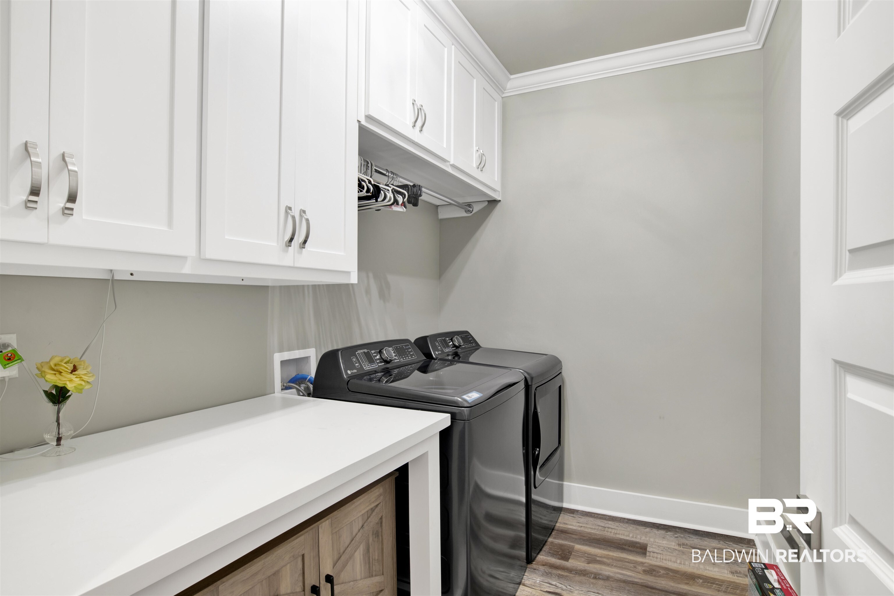 21621 Veranda Boulevard Fairhope, AL 36532 - Photo 17 of 51 Laundry room featuring crown molding, dark wood-style flooring, baseboards, cabinet space, and independent washer and dryer