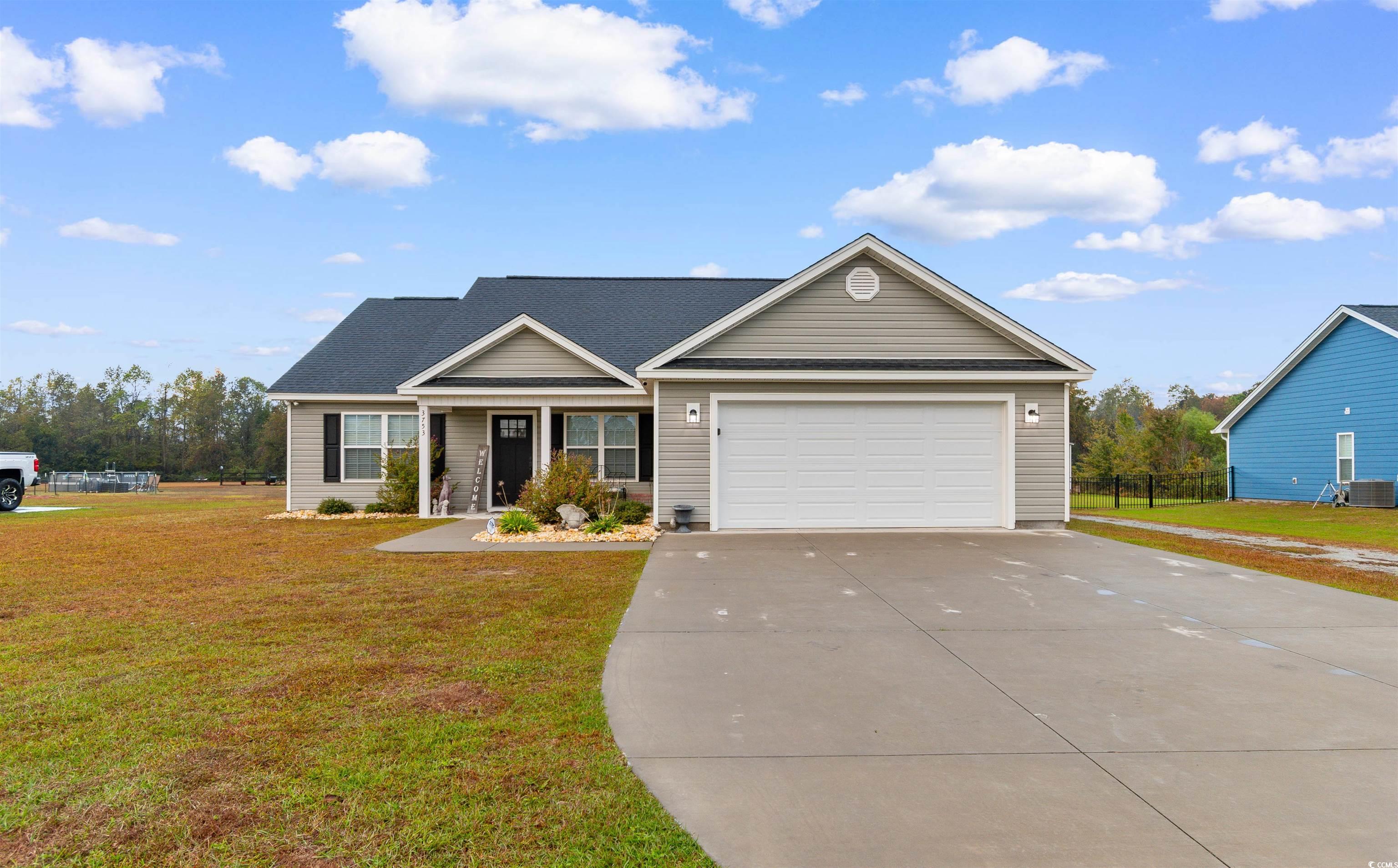View of front facade featuring a porch, concrete driveway, a garage, and a shingled roof