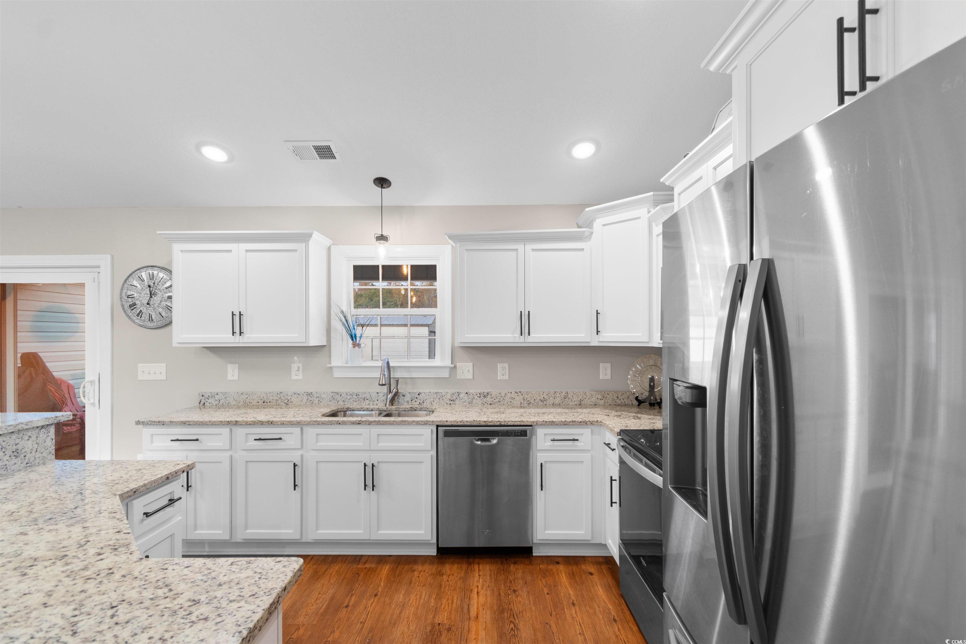 3753 Edwards Road Aynor, SC 29544 - Photo 11 of 38 Kitchen featuring appliances with stainless steel finishes, white cabinets, decorative light fixtures, light stone counters, and recessed lighting