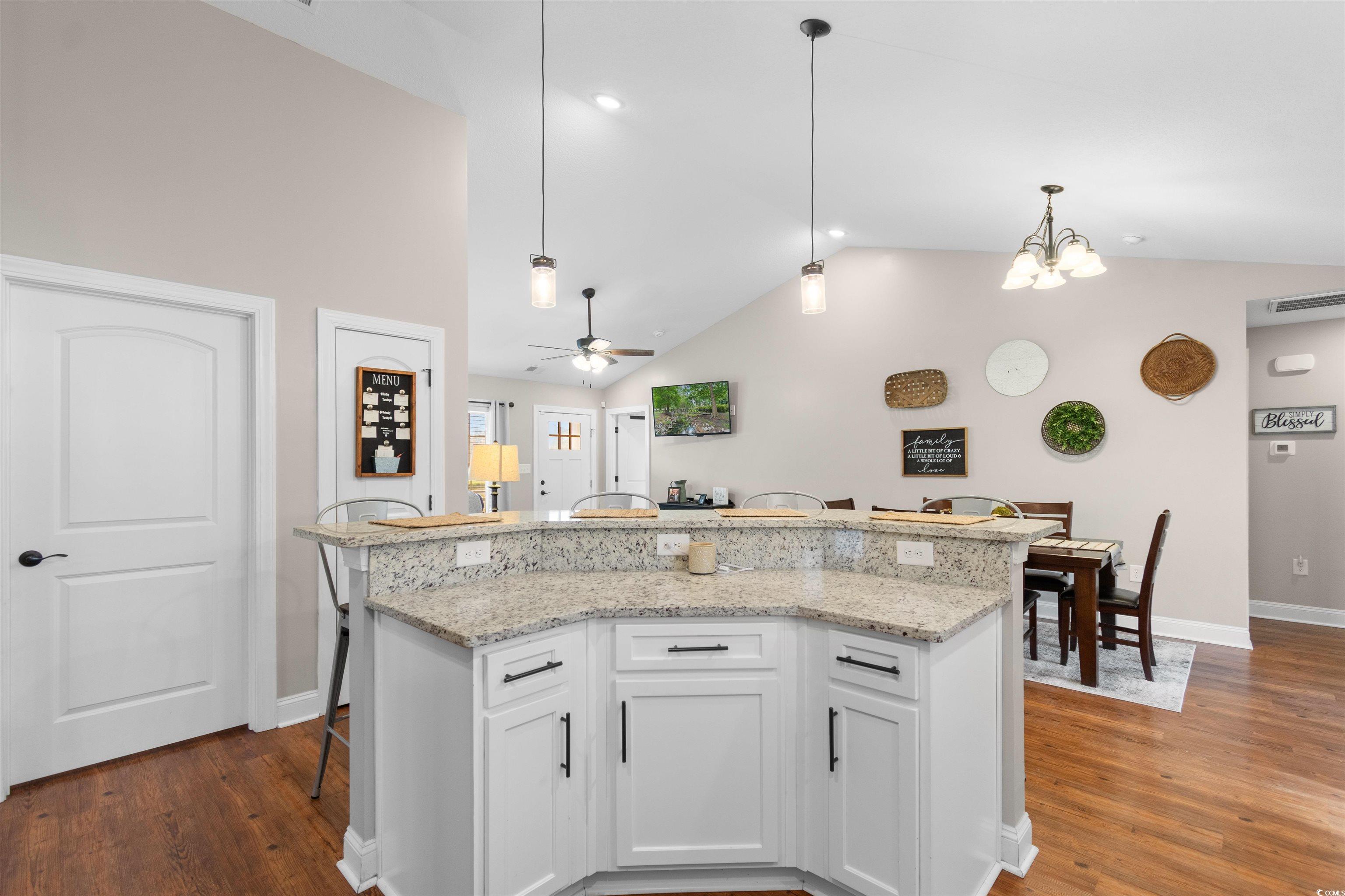 3753 Edwards Road Aynor, SC 29544 - Photo 12 of 38 Kitchen featuring a kitchen bar, hanging light fixtures, white cabinetry, light stone counters, and high vaulted ceiling