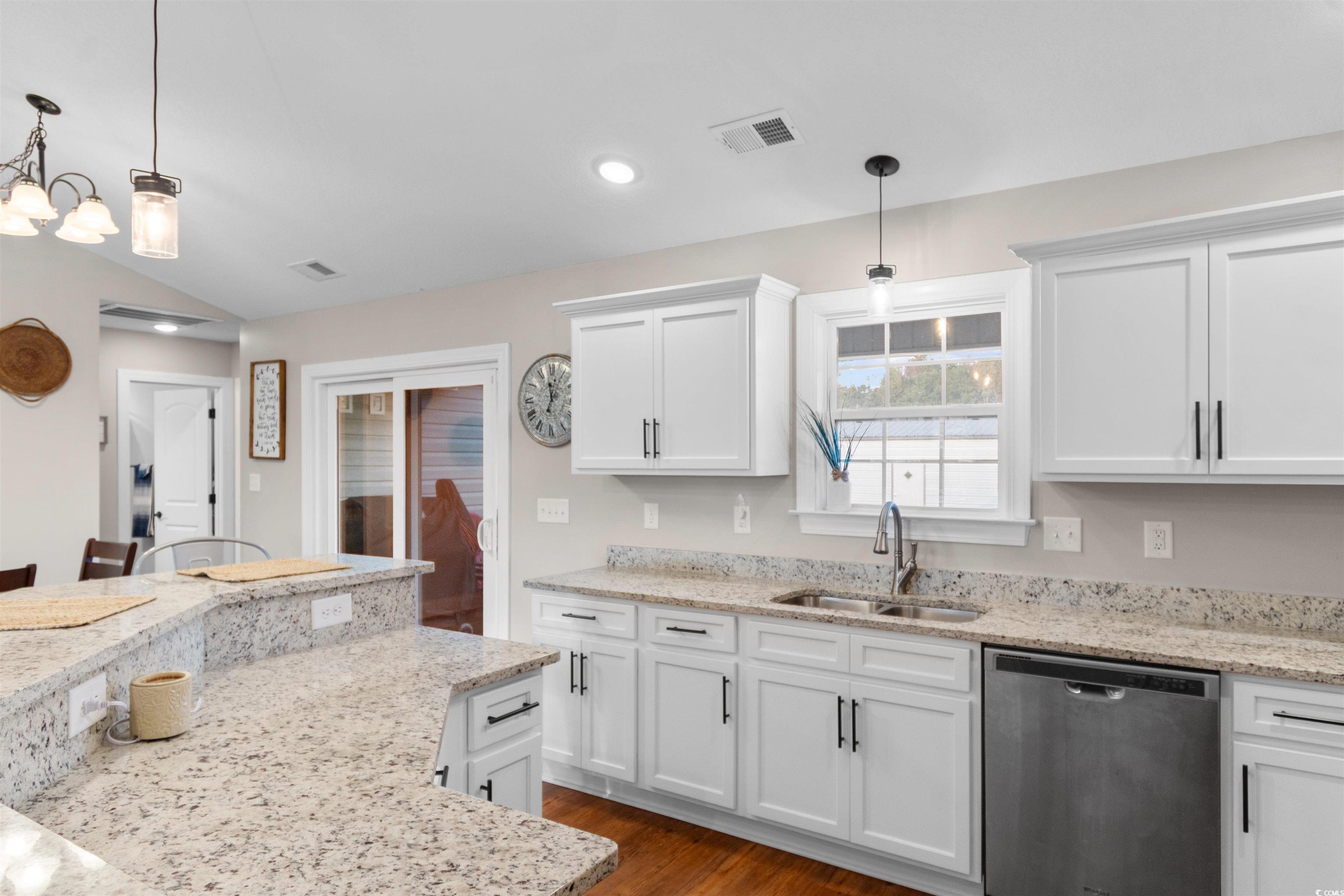 3753 Edwards Road Aynor, SC 29544 - Photo 15 of 38 Kitchen featuring hanging light fixtures, stainless steel dishwasher, dark wood-style flooring, white cabinetry, and light stone countertops