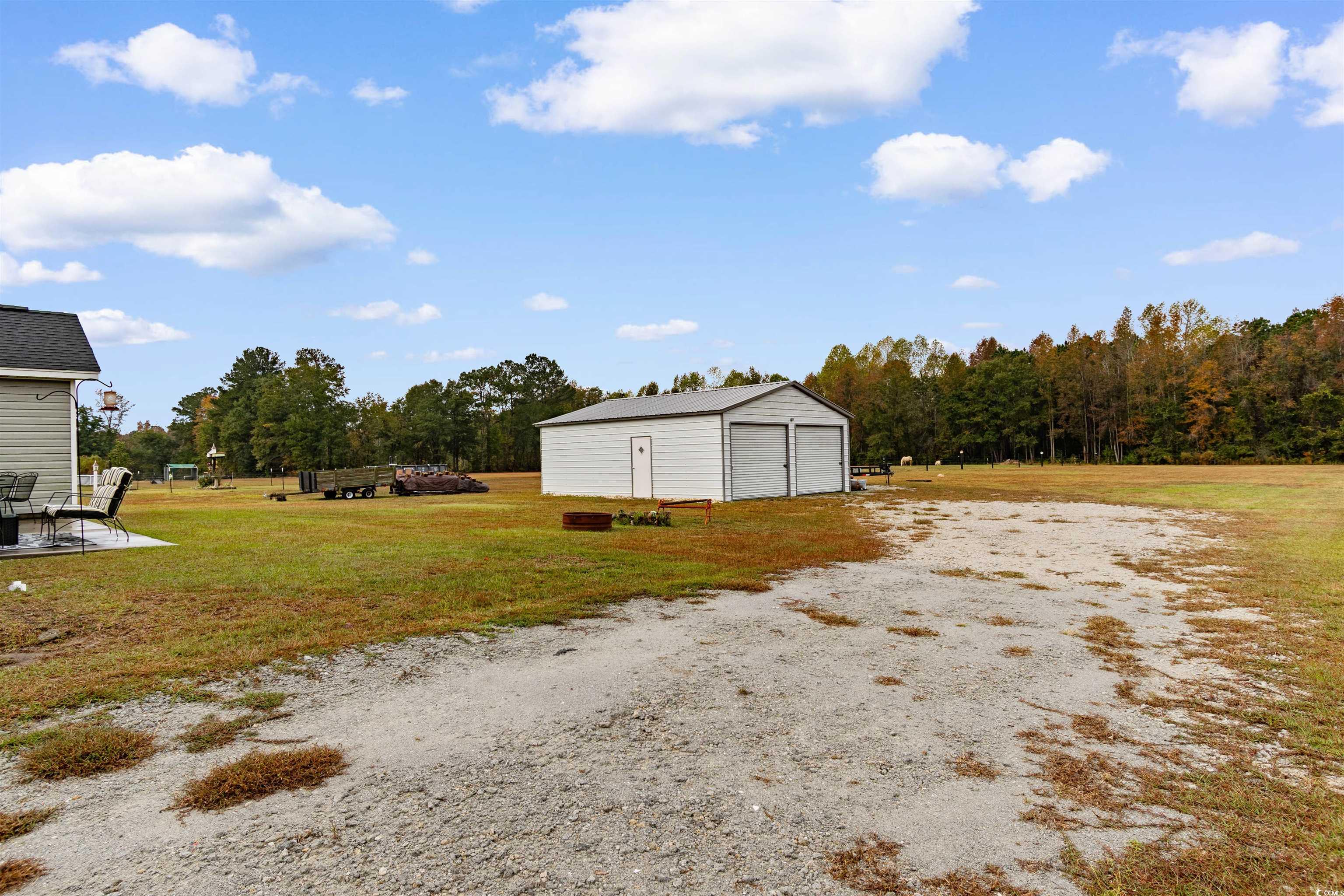 3753 Edwards Road Aynor, SC 29544 - Photo 28 of 38 View of grassy yard with a detached garage, an outdoor structure, and a patio