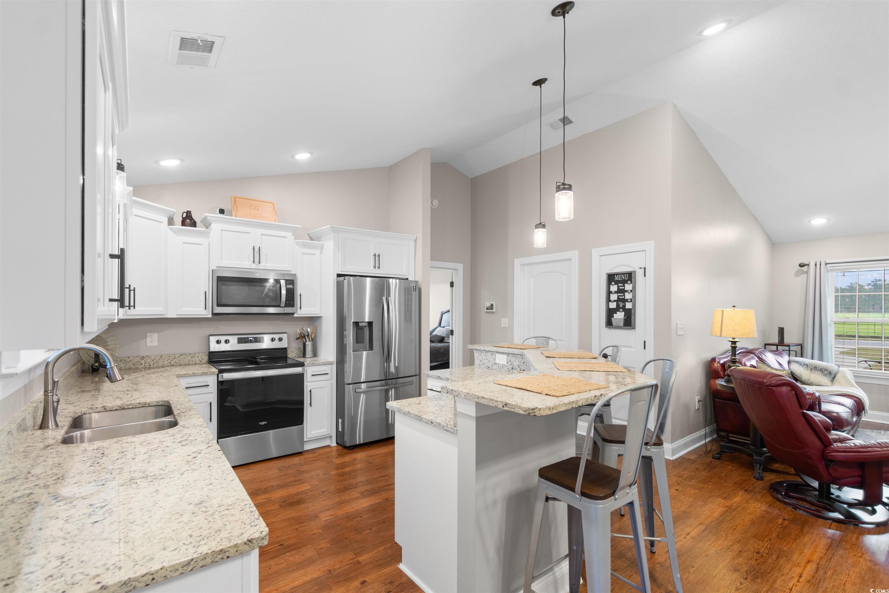 3753 Edwards Road Aynor, SC 29544 - Photo 8 of 38 Kitchen with appliances with stainless steel finishes, decorative light fixtures, a breakfast bar area, white cabinetry, and dark wood finished floors