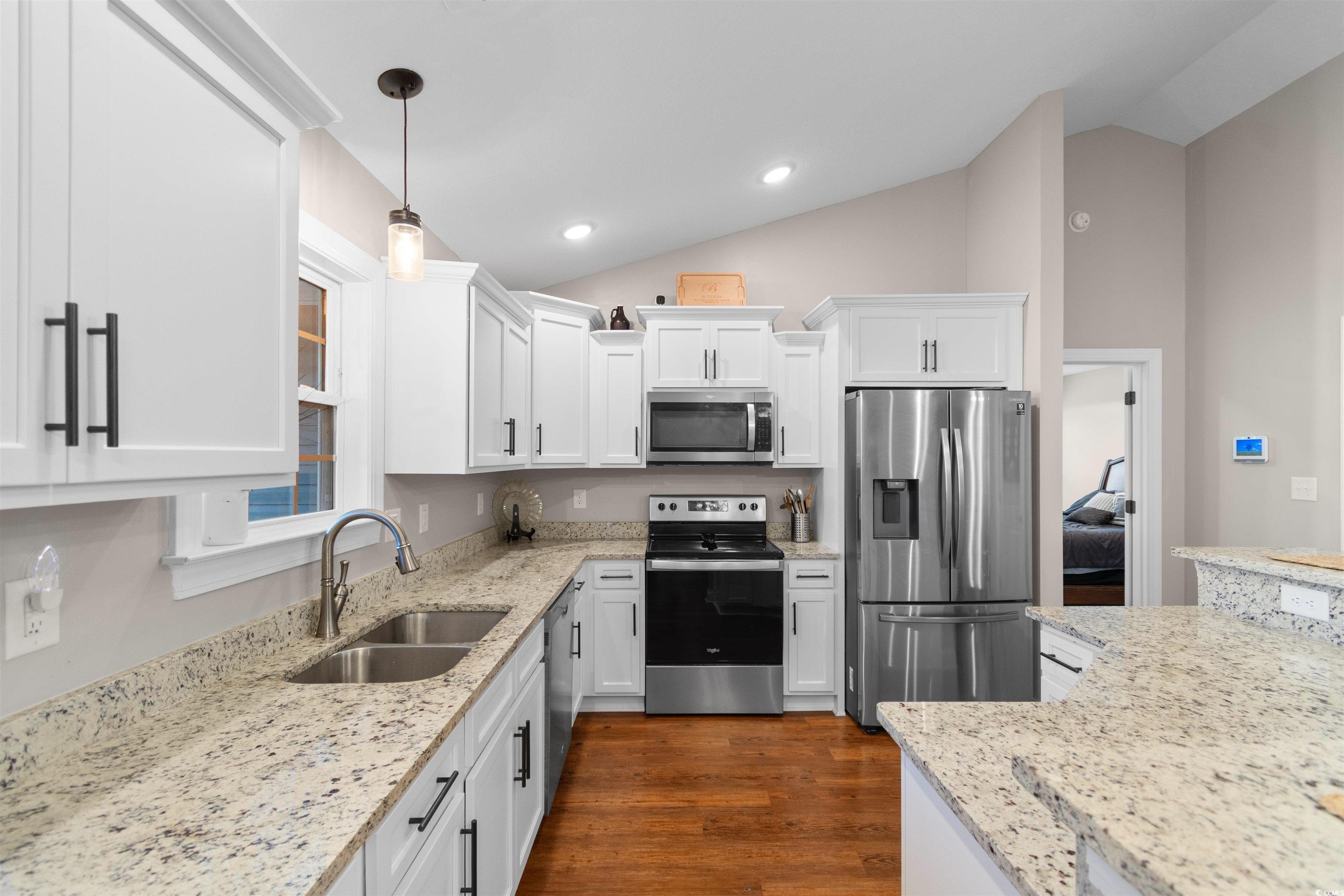 3753 Edwards Road Aynor, SC 29544 - Photo 9 of 38 Kitchen with appliances with stainless steel finishes, pendant lighting, light stone countertops, white cabinets, and vaulted ceiling