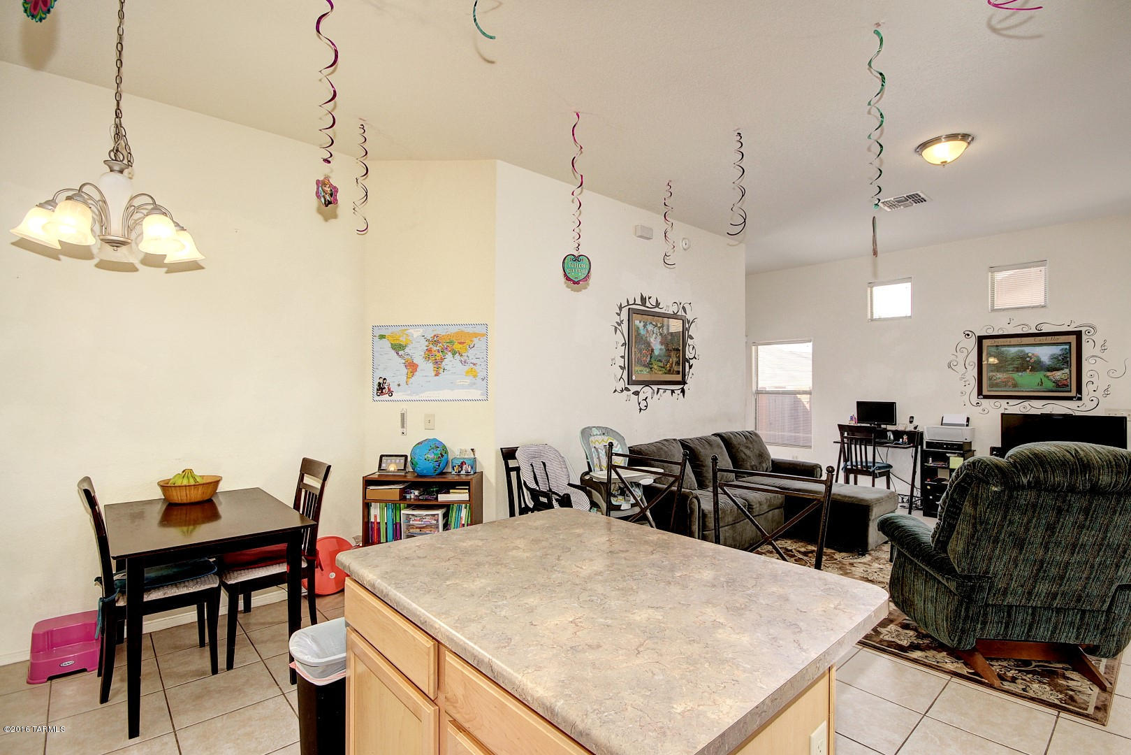 6016 South Avenida Ribero Tucson, AZ 85706 - Photo 6 of 15 a living room with a couch a dining table and a chandelier